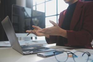 Cropped image of professional businesswoman working at her office via laptop, young female manager using portable computer device while sitting at modern loft, flare light, work process concept photo