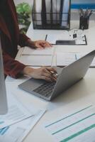 Cropped image of professional businesswoman working at her office via laptop, young female manager using portable computer device while sitting at modern loft, flare light, work process concept photo