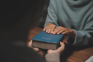 Christian group are praying to god with the bible and sharing the gospel. Concept of faith for god. photo