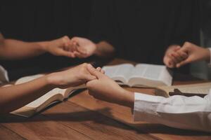 Christian group are praying to god with the bible and sharing the gospel. Concept of faith for god. photo