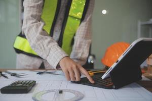 engineer people meeting working and pointing at a blueprint in office for discussing. Engineering tools and construction concept photo