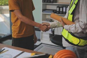 Architect men making handshake in construction site. Employee or worker shake hands to employer man for greeting, dealing, teamwork, collaboration some project or business. They are good team photo