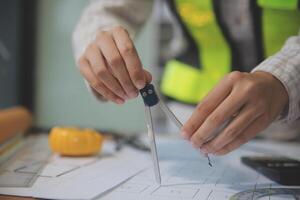 engineer people meeting working and pointing at a blueprint in office for discussing. Engineering tools and construction concept photo