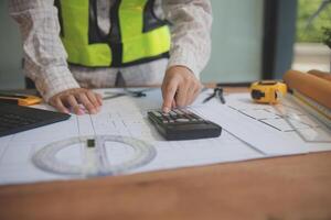 engineer people meeting working and pointing at a blueprint in office for discussing. Engineering tools and construction concept photo
