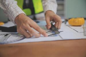 engineer people meeting working and pointing at a blueprint in office for discussing. Engineering tools and construction concept photo