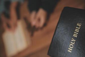 Christian group are praying to god with the bible and sharing the gospel. Concept of faith for god. photo