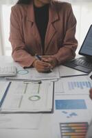 Close up of Business team analyzing income charts and graphs with modern laptop computer. Business analysis and strategy concept. photo