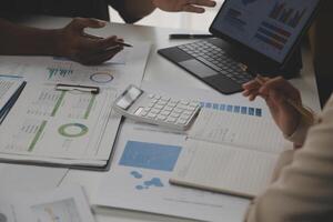 Close up of Business team analyzing income charts and graphs with modern laptop computer. Business analysis and strategy concept. photo