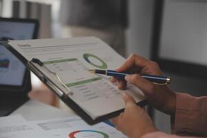 Close up of Business team analyzing income charts and graphs with modern laptop computer. Business analysis and strategy concept. photo