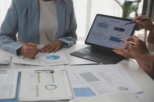 Close up of Business team analyzing income charts and graphs with modern laptop computer. Business analysis and strategy concept. photo