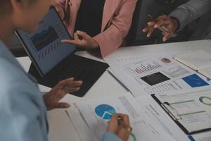 Close up of Business team analyzing income charts and graphs with modern laptop computer. Business analysis and strategy concept. photo