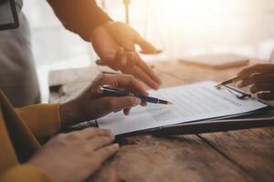 Business and lawyers discussing contract papers with brass scale on desk in office. Law, legal services, advice, justice and law concept picture with film grain effect photo