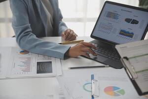 Close up of Business team analyzing income charts and graphs with modern laptop computer. Business analysis and strategy concept. photo