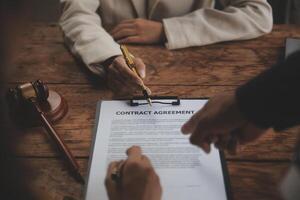 Business and lawyers discussing contract papers with brass scale on desk in office. Law, legal services, advice, justice and law concept picture with film grain effect photo