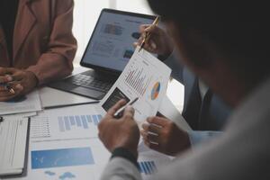 Close up of Business team analyzing income charts and graphs with modern laptop computer. Business analysis and strategy concept. photo