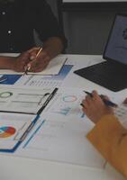 Close up of Business team analyzing income charts and graphs with modern laptop computer. Business analysis and strategy concept. photo