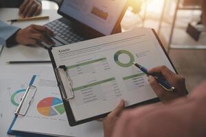 Close up of Business team analyzing income charts and graphs with modern laptop computer. Business analysis and strategy concept. photo