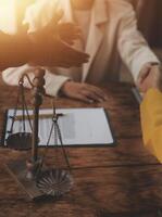 Lawyer shaking hands with a client making about documents, contracts, agreements, cooperation agreements with a female client at the lawyer's desk and a hammer at the table. photo