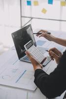 Financial analysts analyze business financial reports on a digital tablet planning investment project during a discussion at a meeting of corporate showing the results of their successful teamwork. photo