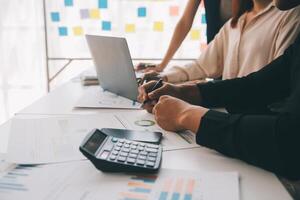 Financial analysts analyze business financial reports on a digital tablet planning investment project during a discussion at a meeting of corporate showing the results of their successful teamwork. photo