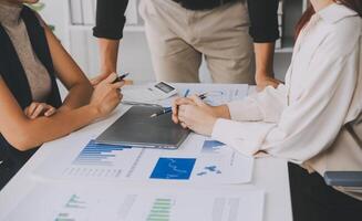 Financial analysts analyze business financial reports on a digital tablet planning investment project during a discussion at a meeting of corporate showing the results of their successful teamwork. photo