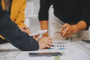 Financial analysts analyze business financial reports on a digital tablet planning investment project during a discussion at a meeting of corporate showing the results of their successful teamwork. photo