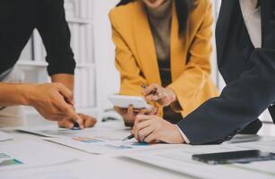 Financial analysts analyze business financial reports on a digital tablet planning investment project during a discussion at a meeting of corporate showing the results of their successful teamwork. photo