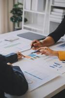 Financial analysts analyze business financial reports on a digital tablet planning investment project during a discussion at a meeting of corporate showing the results of their successful teamwork. photo