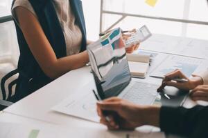 Financial analysts analyze business financial reports on a digital tablet planning investment project during a discussion at a meeting of corporate showing the results of their successful teamwork. photo