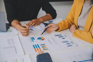 Financial analysts analyze business financial reports on a digital tablet planning investment project during a discussion at a meeting of corporate showing the results of their successful teamwork. photo