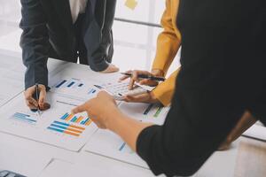 Financial analysts analyze business financial reports on a digital tablet planning investment project during a discussion at a meeting of corporate showing the results of their successful teamwork. photo