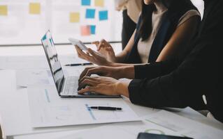 Financial analysts analyze business financial reports on a digital tablet planning investment project during a discussion at a meeting of corporate showing the results of their successful teamwork. photo