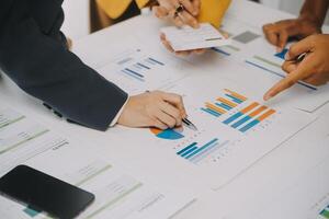 Financial analysts analyze business financial reports on a digital tablet planning investment project during a discussion at a meeting of corporate showing the results of their successful teamwork. photo