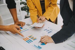 Financial analysts analyze business financial reports on a digital tablet planning investment project during a discussion at a meeting of corporate showing the results of their successful teamwork. photo