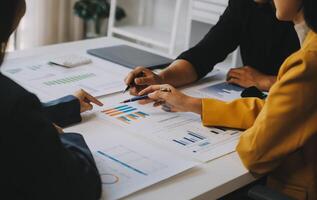 Financial analysts analyze business financial reports on a digital tablet planning investment project during a discussion at a meeting of corporate showing the results of their successful teamwork. photo