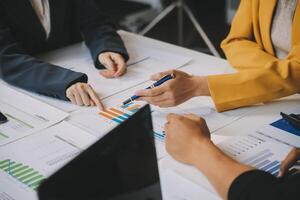 Financial analysts analyze business financial reports on a digital tablet planning investment project during a discussion at a meeting of corporate showing the results of their successful teamwork. photo