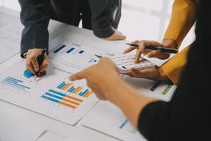 Financial analysts analyze business financial reports on a digital tablet planning investment project during a discussion at a meeting of corporate showing the results of their successful teamwork. photo