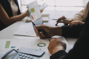 Financial analysts analyze business financial reports on a digital tablet planning investment project during a discussion at a meeting of corporate showing the results of their successful teamwork. photo
