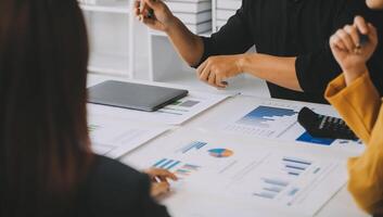 Financial analysts analyze business financial reports on a digital tablet planning investment project during a discussion at a meeting of corporate showing the results of their successful teamwork. photo