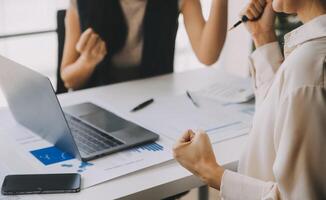 Financial analysts analyze business financial reports on a digital tablet planning investment project during a discussion at a meeting of corporate showing the results of their successful teamwork. photo
