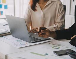 Financial analysts analyze business financial reports on a digital tablet planning investment project during a discussion at a meeting of corporate showing the results of their successful teamwork. photo