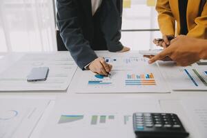 Financial analysts analyze business financial reports on a digital tablet planning investment project during a discussion at a meeting of corporate showing the results of their successful teamwork. photo