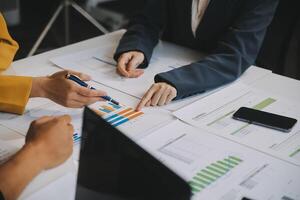 Financial analysts analyze business financial reports on a digital tablet planning investment project during a discussion at a meeting of corporate showing the results of their successful teamwork. photo