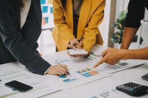Financial analysts analyze business financial reports on a digital tablet planning investment project during a discussion at a meeting of corporate showing the results of their successful teamwork. photo