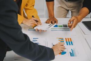 Financial analysts analyze business financial reports on a digital tablet planning investment project during a discussion at a meeting of corporate showing the results of their successful teamwork. photo