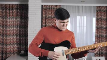 The man plays the guitar vigorously at home. He performs a solo. Euphoria. The pleasure of a hobby. video
