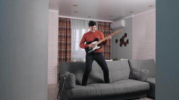 The man is a guy at home playing the guitar. Inspiration. The real thrill of a hobby. The pleasure of playing the guitar. video