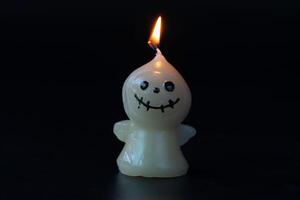 Lit Scarecrow Halloween Candle on Dark Background photo