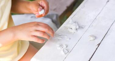Kid hands in the process of creating the handicraft of polymer clay photo