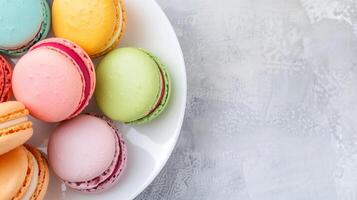 Overhead View of Neatly Stacked Colorful Macarons on White Plate with Textured Background, Perfect for Bakery Advertising, Confectionery Promotion, Pastry Blogs, Dessert Menus, and Food Photography photo